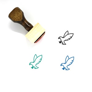 May include: A wooden rubber stamp with a red ink pad. The stamp features a line drawing of a bird with wings spread. The bird is shown in black, teal, and blue.