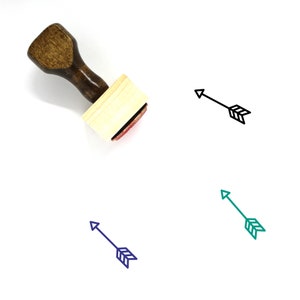 Puede incluir: Sello de madera con mango marrón y un bloque rectangular de madera. El sello presenta un contorno negro de una flecha con plumas. La flecha apunta hacia la derecha. También hay otras tres flechas en diferentes colores: negro, verde y azul.