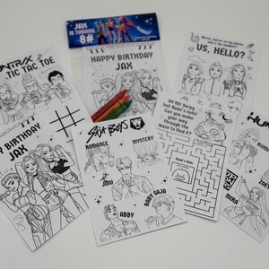Op de afbeelding: Een verzameling zwart-wit kleurplaten met stripfiguren en de tekst "HAPPY BIRTHDAY JAX", "HUNTRAX" en "SAJA BOYS". Inclusief kleurpotloden en een banner met de tekst "JAX IS TURNING 8#".