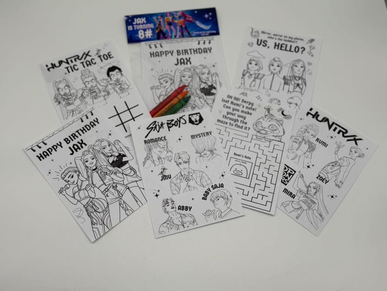 Op de afbeelding: Een verzameling zwart-wit kleurplaten en activiteitenbladen. De bladen bevatten illustraties van mensen, doolhoven en boter-kaas-en-eieren. Sommige bladen hebben tekst met "Happy Birthday Jax", "Saja Boys" en "Us, Hello?"