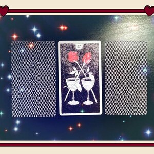 May include: Three rectangular tarot cards arranged horizontally. The center card features a black and white illustration of two chalices with two red roses crossed above them, labeled with the Roman numeral II. The two outer cards show a white grid pattern.