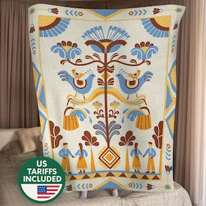 May include: A cream-colored blanket with a folk art design. The design features blue birds, flowers, and figures in yellow, blue, and brown. The blanket has a geometric border and the text "US TARIFFS INCLUDED" with a US flag.