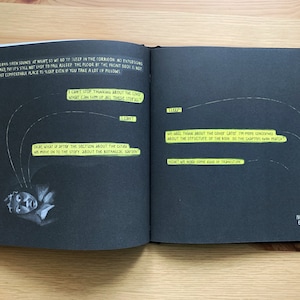 Pode incluir: Um caderno preto com notas escritas &agrave; m&atilde;o em amarelo nas p&aacute;ginas. As notas s&atilde;o sobre a estrutura de um livro e o processo de escrita. A data "Nov 23, 2022" e o nome "67 Rockets" est&atilde;o escritos no canto inferior direito.