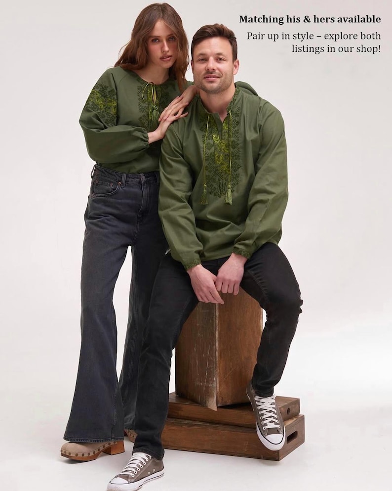 May include: Two people wearing olive green embroidered shirts and dark denim jeans. The shirts have a drawstring neckline and long sleeves. The text "Matching his & hers available" and "Pair up in style - explore both listings in our shop!" is visible.