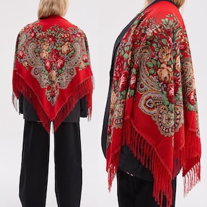 Könnte beinhalten: Ein leuchtend rotes Tuch mit floralem und Paisley-Muster. Das Tuch zeigt ein zentrales Bouquet aus Rosen und anderen Blumen in Rot-, Rosa- und Gelbtönen, umgeben von aufwendigen Paisley-Mustern. Die Kanten sind mit Fransen versehen.