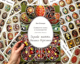 May include: A book titled "Дерево життя. Богиня-Берегиня" by Зоя Сташук. The book cover features a colourful pysanka, a traditional Ukrainian Easter egg, with red, yellow and black geometric patterns. The book is part of a series titled "Символічні знаки в писанкарстві" (Symbolic Signs in Pysanka Art).