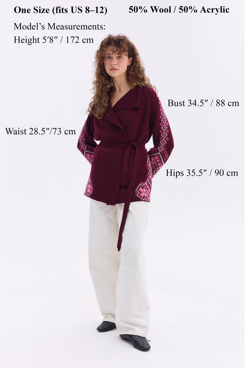 May include: A burgundy wrap sweater with embroidered sleeves and a matching belt. The model's measurements are: height 5'8"/172 cm, bust 34.5"/88 cm, waist 28.5"/73 cm, and hips 35.5"/90 cm. The sweater is one size, fitting US sizes 8-12.