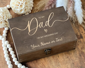 May include: A dark brown wooden box with a hinged lid and a latch. The box is engraved with the words "To My Dad On My Wedding Day" and a small heart. The text "Your Name or Text" is also engraved on the box.