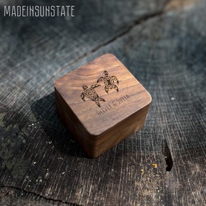 May include: A wooden box with a carved design of two sea turtles. The box is engraved with the names "Oliver & Julia".