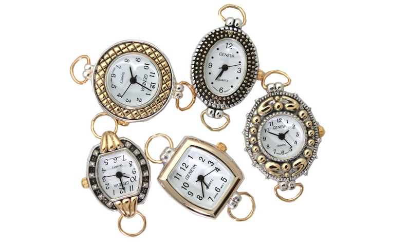 May include: Five silver and gold tone watch charms with white faces and black numbers. The watches have different shapes and designs, including round, oval, and rectangular.