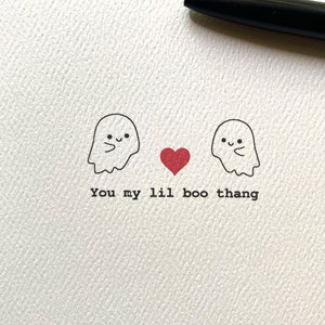 May include: A greeting card with two cartoon ghosts and a red heart between them. The text reads "You my lil boo thang".