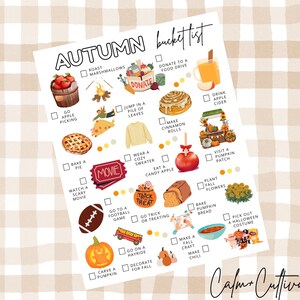 May include: A white paper with an "Autumn bucket list" in black script, featuring illustrations of fall activities like apple picking, baking a pie, and carving pumpkins. The background is a beige and white checkered pattern.
