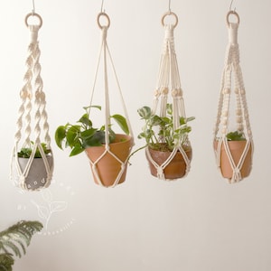 Four elegantly crafted macrame plant hangers without tassels created by Macramebeautiful, displaying green houseplants in terracotta pots against a neutral wall, highlighting the natural beauty and intricate knotting techniques