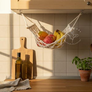 Handmade macramé 1-tier fruit hammock in natural cotton, hanging kitchen fruit basket with apples, oranges and kiwis — boho farmhouse decor, space-saving organizer for countertop or wall.