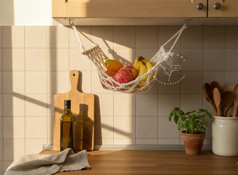 Handmade macramé 1-tier fruit hammock in natural cotton, hanging kitchen fruit basket with apples, oranges and kiwis — boho farmhouse decor, space-saving organizer for countertop or wall.