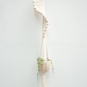Elegant Style B macrame plant hanger with beads, featuring a 100cm long white cotton rope adorned with wooden beads, suspending a terracotta pot with trailing greenery, perfect for stylish indoor gardens.