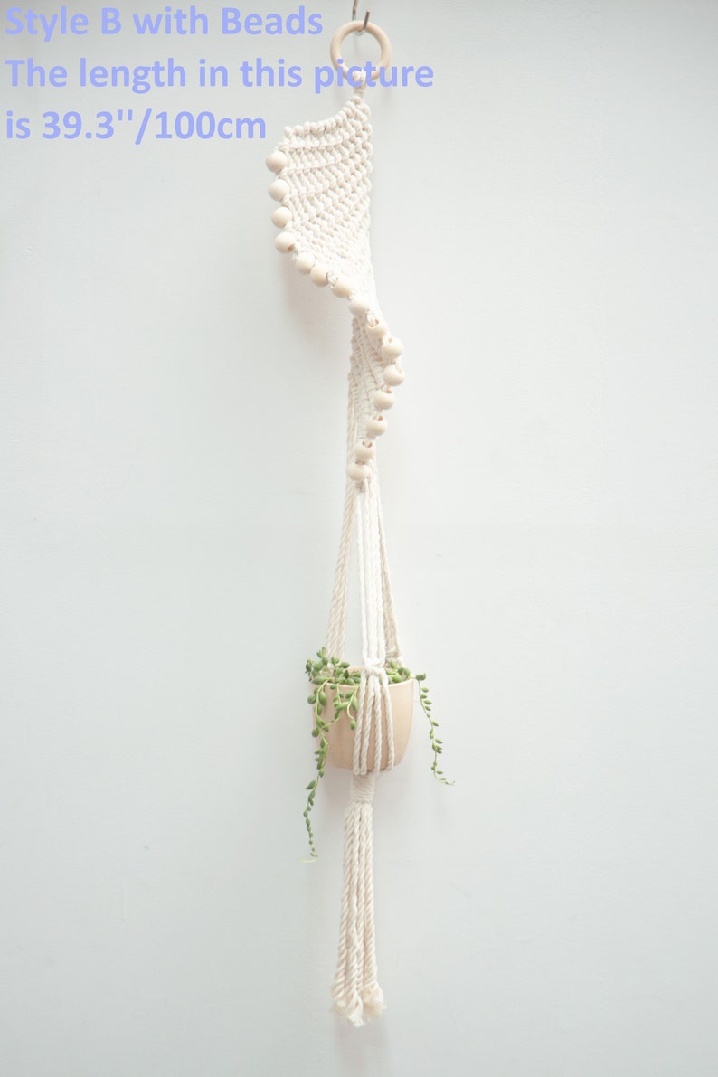 Elegant Style B macrame plant hanger with beads, featuring a 100cm long white cotton rope adorned with wooden beads, suspending a terracotta pot with trailing greenery, perfect for stylish indoor gardens.
