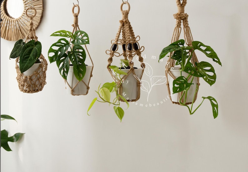 Handcrafted jute macramé plant hangers with wooden rings, featuring four distinct knot patterns suspending white ceramic pots filled with lush green pothos and monstera vines—boho-chic indoor décor perfect for hanging planters, windowsills, balconies.