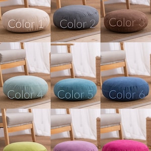 May include: A collection of nine round floor cushions in various colors, including beige, gray, brown, teal, blue, green, purple, and pink. Each cushion is labeled with a color number.