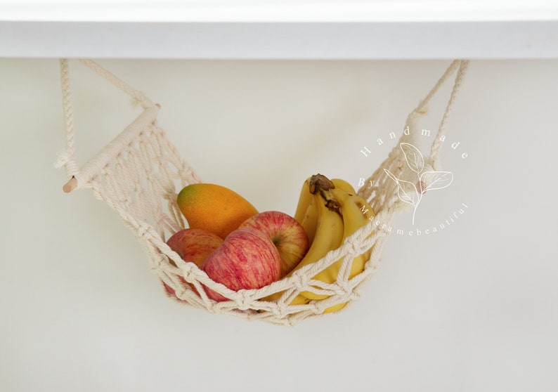 A close-up of a macrame fruit hammock cradling a vibrant selection of tomatoes and mushrooms, featuring intricate knotting patterns, perfect for a minimalist kitchen aesthetic