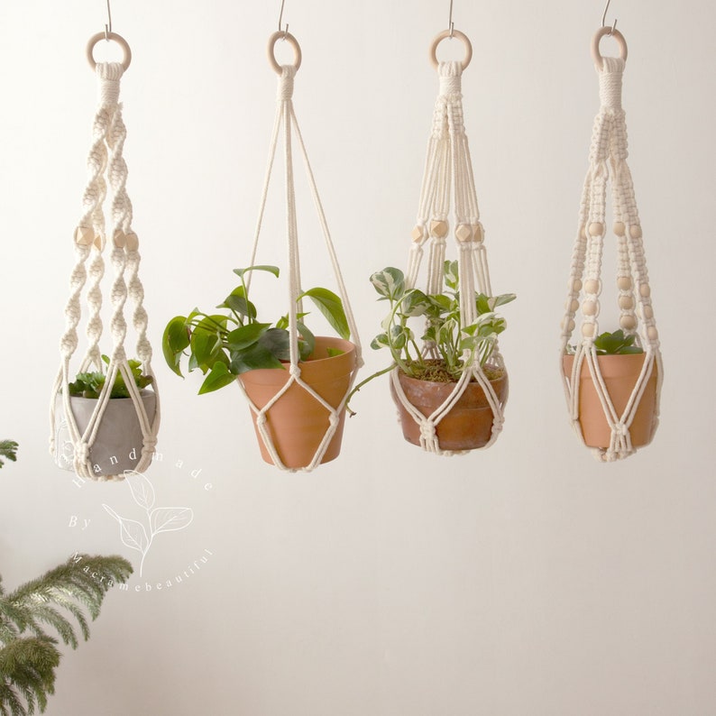 Four elegantly crafted macrame plant hangers without tassels created by Macramebeautiful, displaying green houseplants in terracotta pots against a neutral wall, highlighting the natural beauty and intricate knotting techniques