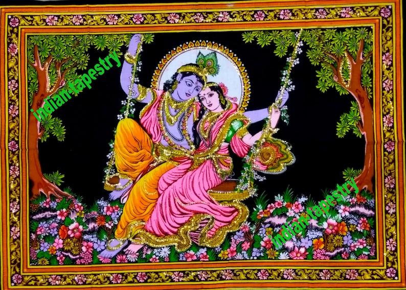 K&ouml;nnte beinhalten: Eine farbenfrohe Wandteppich, der ein Paar auf einer Schaukel in einem &uuml;ppigen gr&uuml;nen Wald zeigt. Das Paar ist in traditioneller indischer Kleidung gekleidet, die Frau tr&auml;gt ein rosa und gr&uuml;nes Sari und der Mann einen blauen und gelben Dhoti. Der Wandteppich ist mit einem goldenen Rahmen versehen und weist komplizierte Details auf.