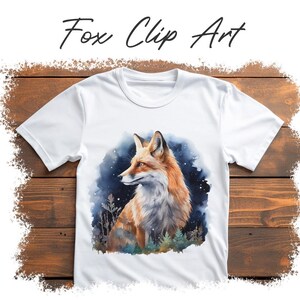 May include: White t-shirt featuring a watercolor illustration of a fox with orange and white fur, set against a dark blue and green background. The text "Fox Clip Art" is written above the image in black script.