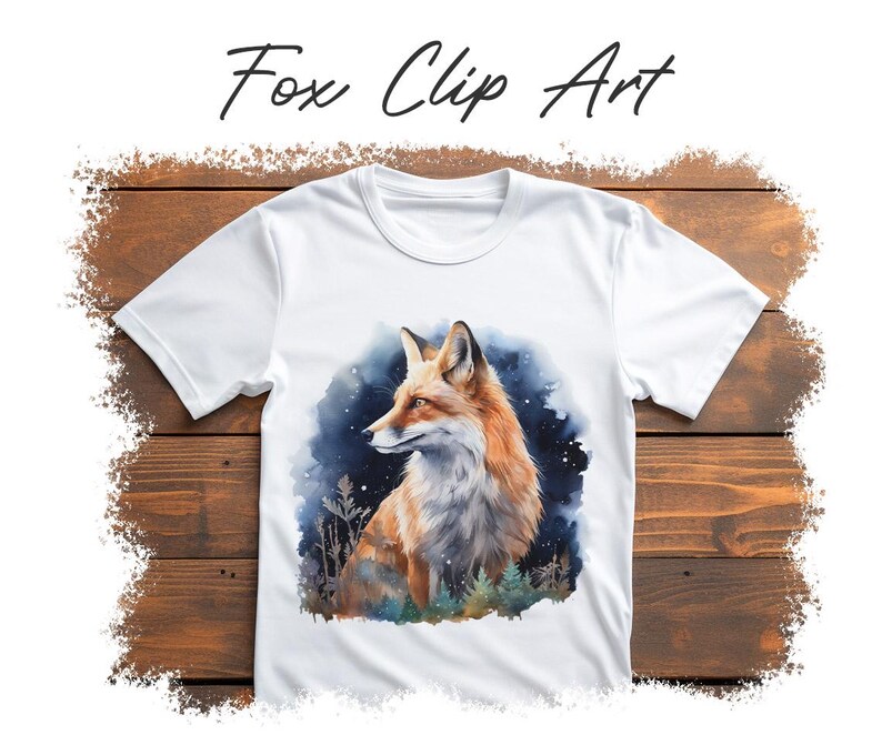 May include: White t-shirt featuring a watercolor illustration of a fox with orange and white fur, set against a dark blue and green background. The text "Fox Clip Art" is written above the image in black script.