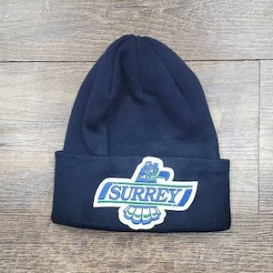 May include: Black beanie with a blue and green eagle logo and the word "SURREY" in white.