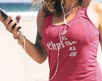 May include: A woman wearing a red tank top with the words "Jesus Christ" printed on it. She is wearing denim shorts and holding a phone. The image also includes a logo with a cross and the words "My Righteous Apparel".