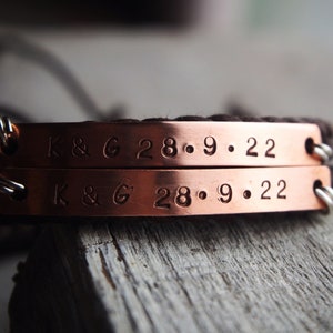 May include: Two copper bracelets with brown leather straps. The bracelets are engraved with "K & G 28.9.22".