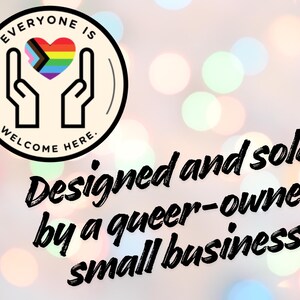 May include: A circular logo featuring two hands cupping a heart with the Progress Pride flag colours, surrounded by the text "EVERYONE IS WELCOME HERE." Below the logo, black text reads "Designed and sold by a queer-owned small business."