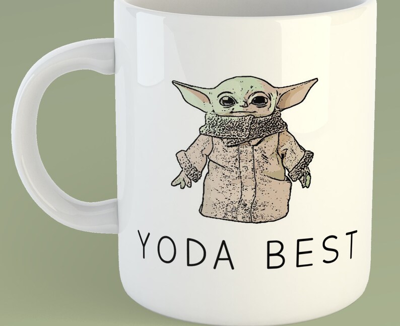 May include: White ceramic mug with a cartoon image of a green alien character wearing a brown coat and the text "Yoda Best" printed on the front.