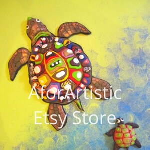 May include: A colorful, mosaic-style turtle sculpture with smaller turtles swimming below. The large turtle has a red, green, yellow, blue, and white shell. The smaller turtles are brown with green, red, and white shells.