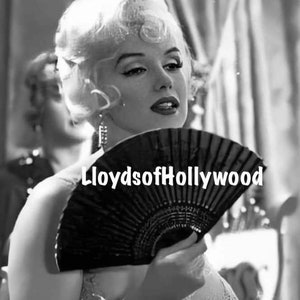 May include: Black and white image of a woman holding a black fan. The text "LloydsofHollywood" is displayed on the fan. The woman has blonde hair and is wearing a dress.