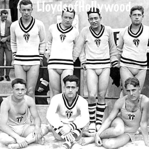 Puede incluir: Fotografía vintage en blanco y negro de un grupo de hombres en trajes de baño y suéteres. Los suéteres color crema tienen ribetes negros y un escudo. Los hombres posan al aire libre.