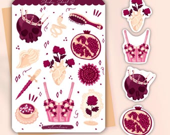 May include: A sticker sheet labeled Sticker Sheet 167 featuring illustrations of a dark purple skull with a crown, a snake, a hairbrush, a pomegranate, a seashell, a dagger, a floral corset, a teacup, and a rose in a frame, plus loose stickers.