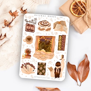 May include: A sticker sheet with a cosy autumn theme featuring illustrations of books, a cinnamon roll, a window with lights, a cup of coffee, and a person reading a book. The sheet is white with gold accents and the text "Sticker Sheet 295" and "ARTIMATION1104".