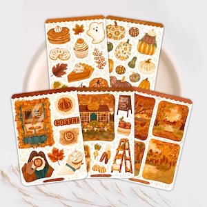 May include: A set of decorative stickers with an autumnal theme. The stickers depict illustrations of pumpkins, autumn treats such as pie and pancakes, and fall scenes. The colour palette includes shades of orange, brown, and cream.