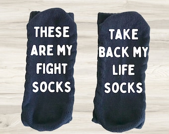 May include: A pair of dark blue socks with white text. One sock says "These are my fight socks" and the other says "Take back my life socks".