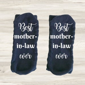 Könnte beinhalten: Ein Paar dunkelblaue Socken mit weißem Text, der "Best mother-in-law ever" lautet.