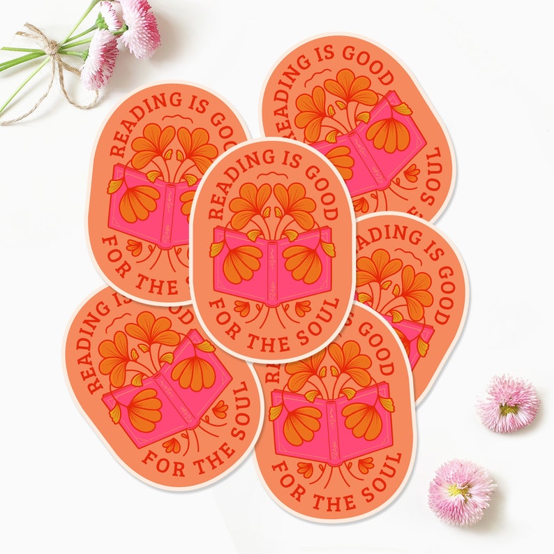 Pode incluir: Seis adesivos ovais cor de p&ecirc;ssego com o texto "Ler &eacute; bom para a alma" em uma fonte retr&ocirc;. Cada adesivo apresenta um livro aberto rosa com flores laranja crescendo dele.