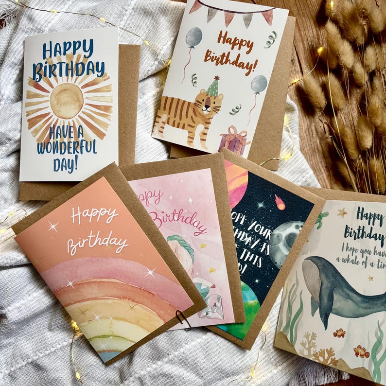 May include: A selection of birthday cards with different designs. One card displays a sun illustration and the text "Happy Birthday! Have a Wonderful Day!". Other cards feature a tiger, a rainbow, and a whale.