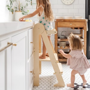 toddler using learning tower over kitchen sink