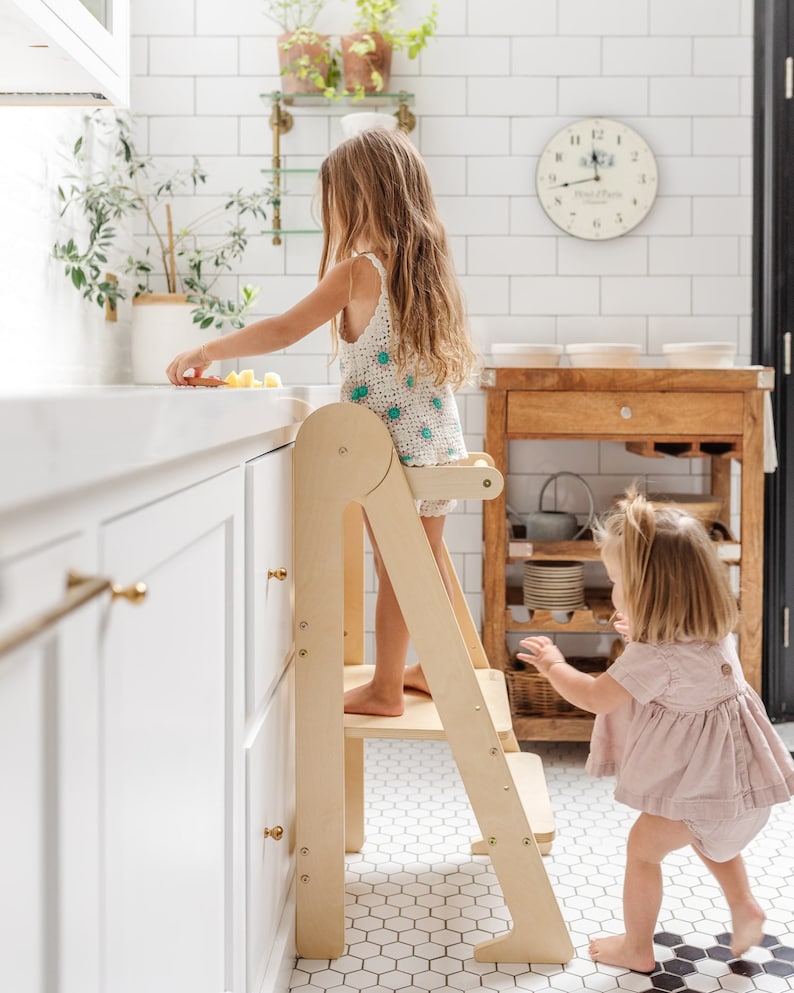 toddler using learning tower over kitchen sink