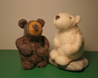 Pode incluir: Um urso marrom e um urso polar branco de pelúcia. Ambos são feitos de feltro e têm um design simples.