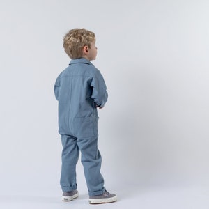 Young boy looking away from the camera modelling blue boilersuit