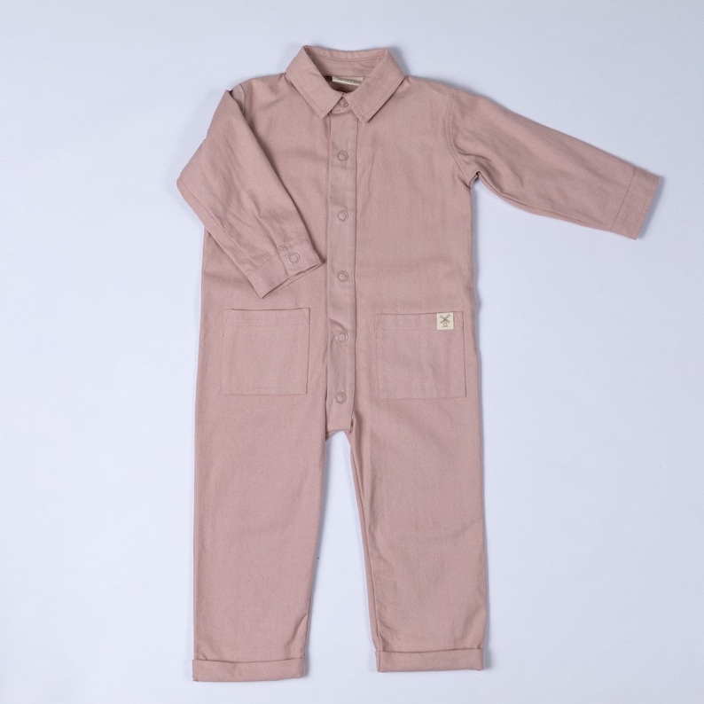 Product shot of the dusty pink boilersuit with Aneby hem tag