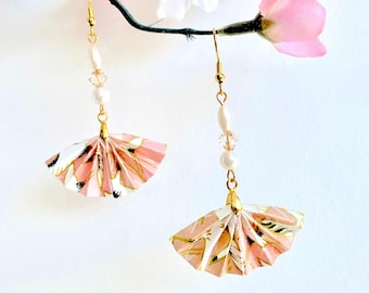 May include: A pair of pink and gold origami fan earrings with white pearl and crystal beads. The earrings are hanging from a branch with pink flowers.
