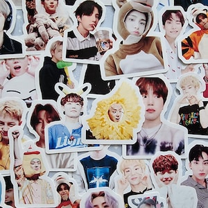 May include: A collection of colourful stickers featuring various images of young men. The stickers are printed on white paper and have a glossy finish. Some of the stickers feature the men wearing animal costumes, while others show them in casual clothing. The stickers are perfect for adding a personal touch to laptops, water bottles, or other items.